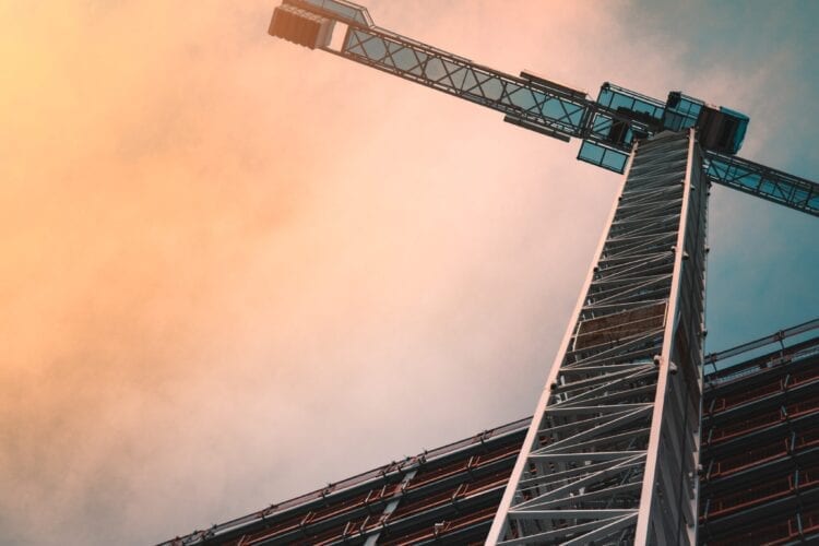 low angle photography of gray tower crane