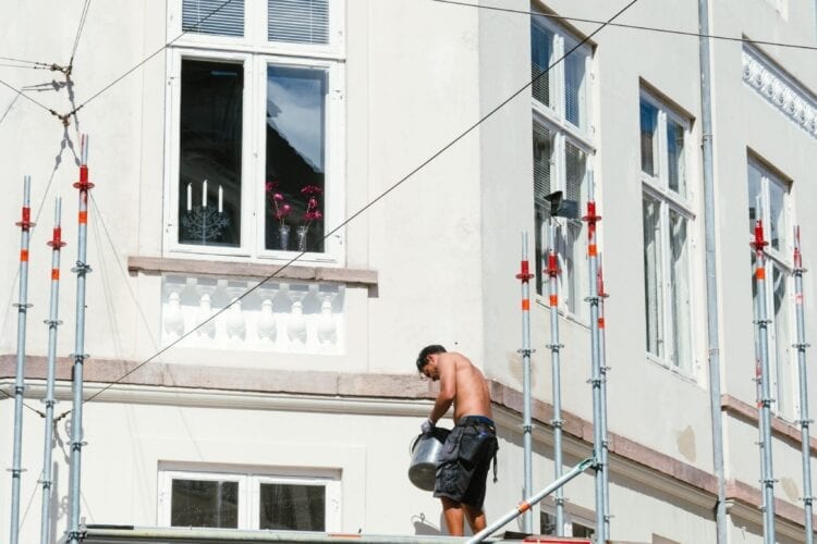 man in black t-shirt and black shorts sitting on black metal railings during daytime