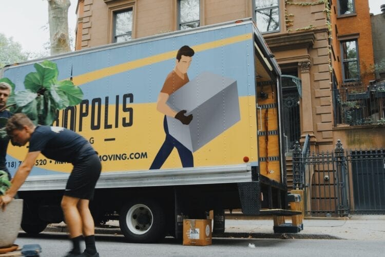 woman in blue shorts and black boots standing beside yellow and white truck during daytime