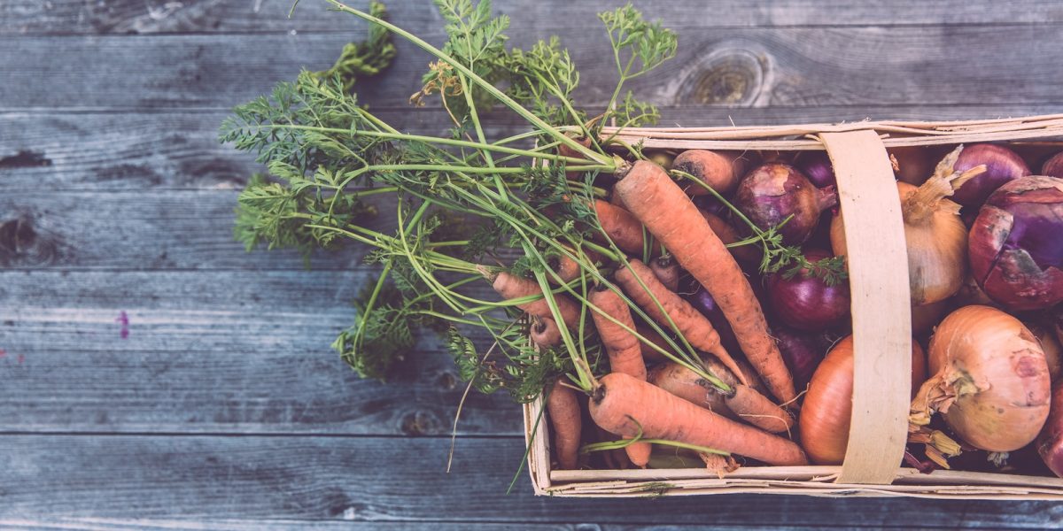 carrots and onions in brown wicker basket