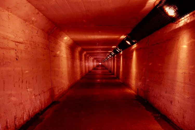 concrete tunnel with red lights